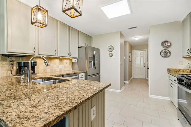 a kitchen with stainless steel appliances granite countertop a stove and a sink
