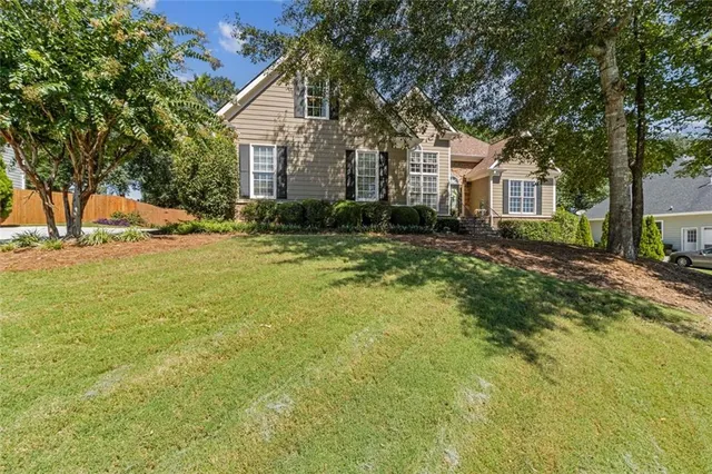 a view of a house with a yard and tree s