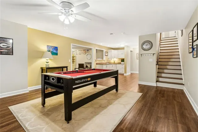 a living room with couches and potted plants with wooden floor