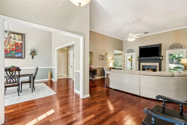 a living room with furniture a flat screen tv and kitchen view