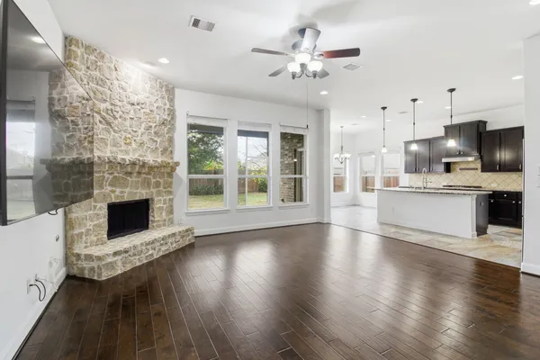 a view of a kitchen with furniture a fireplace and wooden floor