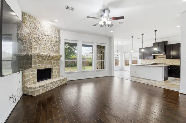 a view of a kitchen with furniture a fireplace and wooden floor