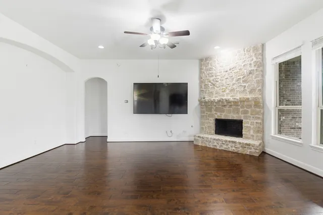 a view of an empty room with a fireplace and a window