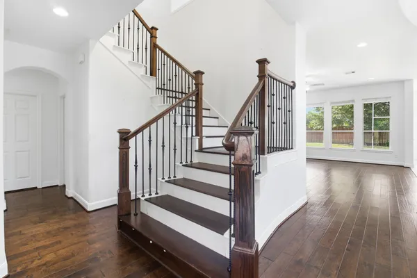 a view of staircase with wooden floor and white walls