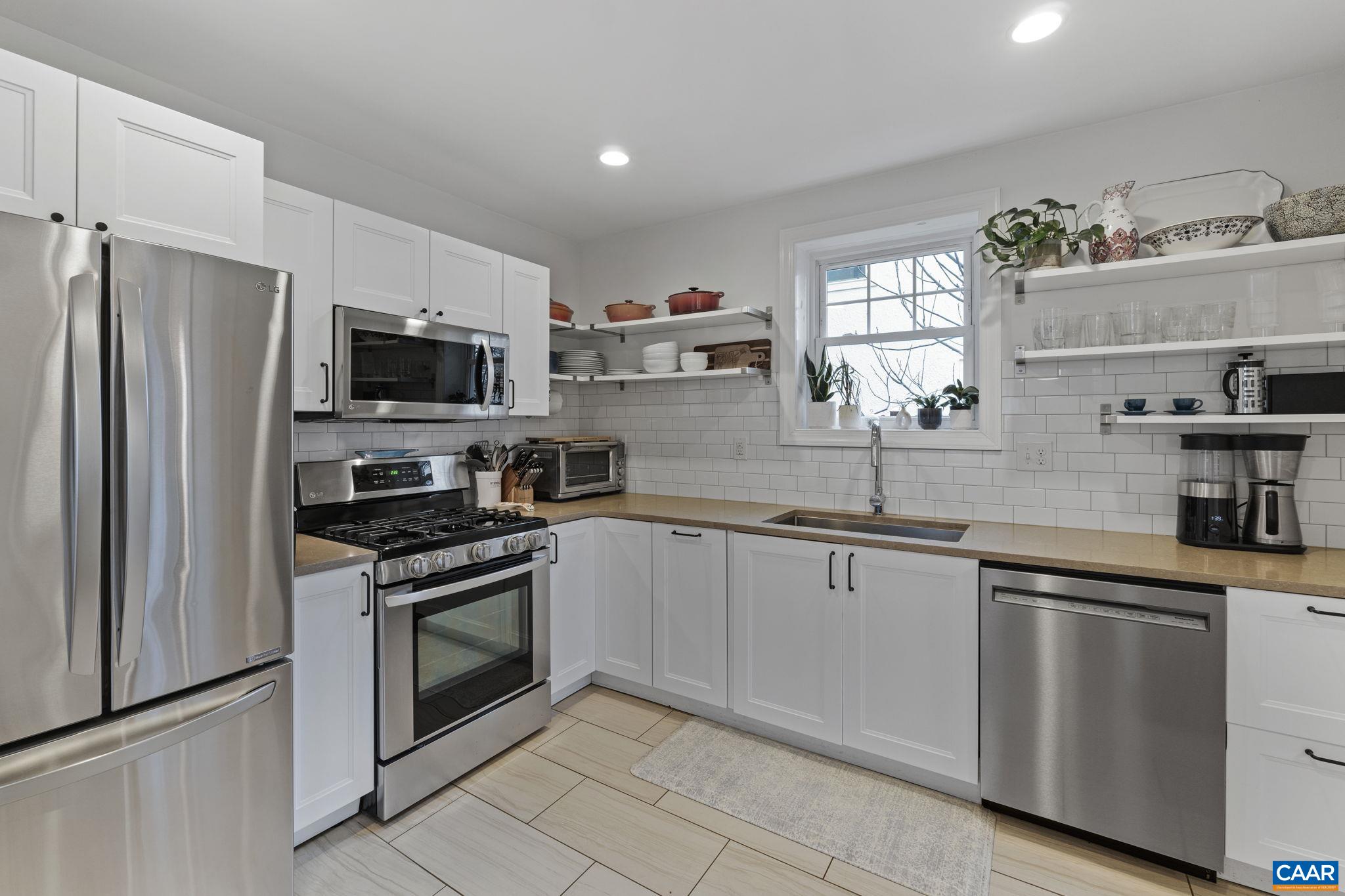 1105 Avon Street Charlottesville, VA 22902 - Photo 11 of 51 a kitchen with granite countertop a sink stainless steel appliances and white cabinets