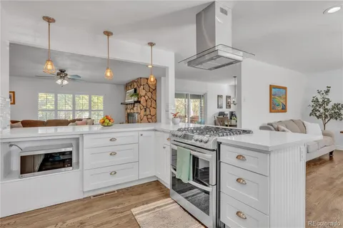a kitchen with a stove and a sink dishwasher with wooden floor