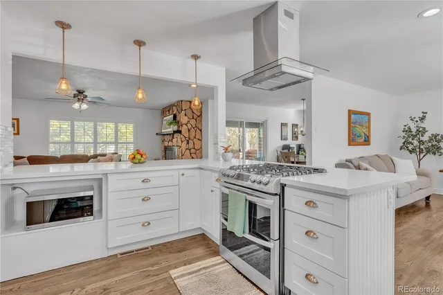 a kitchen with a stove and a sink dishwasher with wooden floor