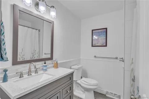 a bathroom with a sink vanity mirror and toilet
