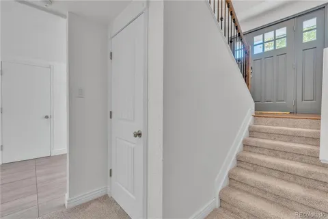 a view of staircase with white walls and door
