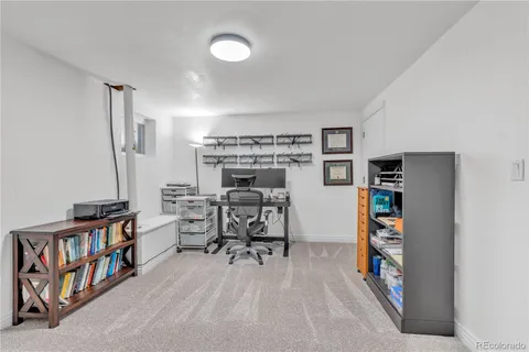 a view of a workspace with furniture and a bookshelf