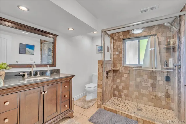 a bathroom with a double vanity sink toilet and shower