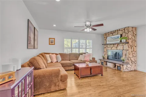 a living room with furniture fireplace and a large window