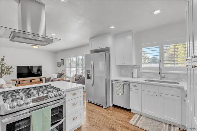 a kitchen with stainless steel appliances granite countertop a sink stove and refrigerator