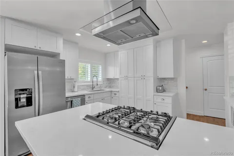 a kitchen with stainless steel appliances granite countertop a sink stove and refrigerator