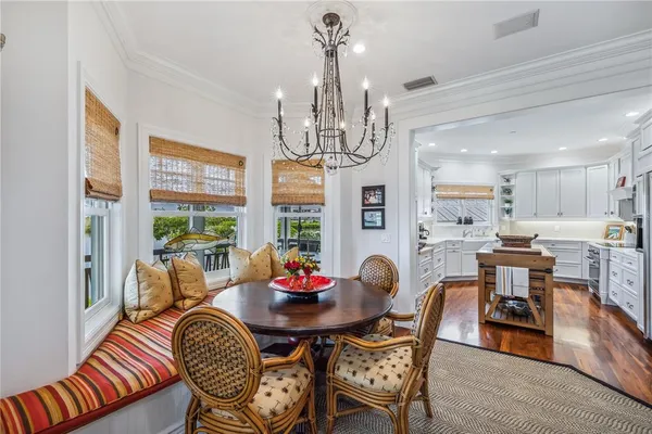 a view of a dining room with furniture a chandelier and wooden floor