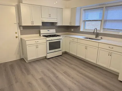 a kitchen with cabinets stainless steel appliances and sink