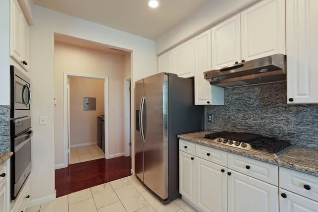 a kitchen with stainless steel appliances granite countertop a refrigerator and a stove