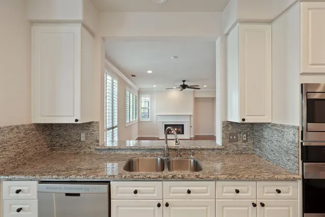 a kitchen with granite countertop white cabinets and white appliances