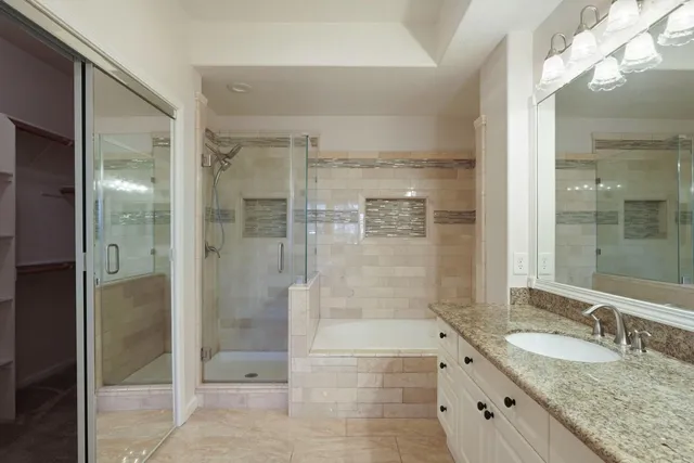 a bathroom with a granite countertop shower mirror and a sink