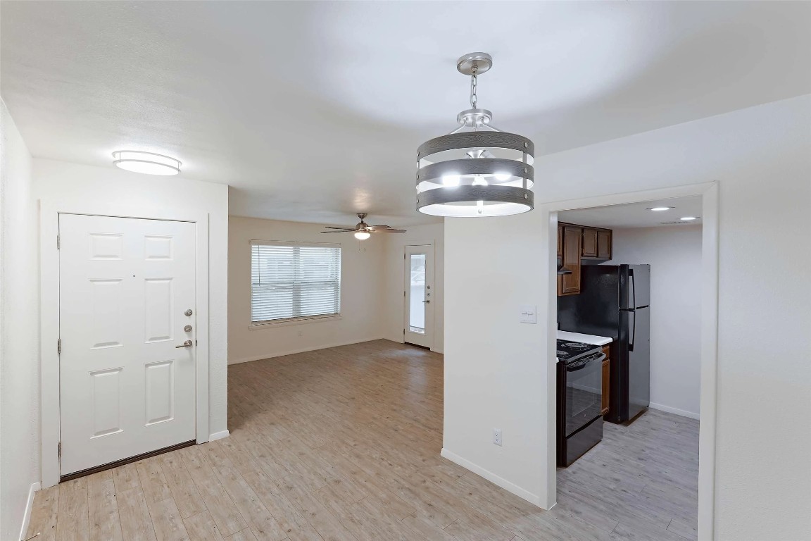 8405 Bent Tree Road, Unit 3414 Austin, TX 78759 - Photo 4 of 20 Kitchen with black appliances, hanging light fixtures, light wood-style floors, light countertops, and a ceiling fan