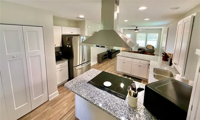 a kitchen with stainless steel appliances granite countertop a refrigerator and a sink