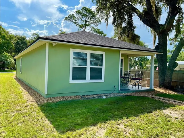 a view of a house with a yard and potted plants