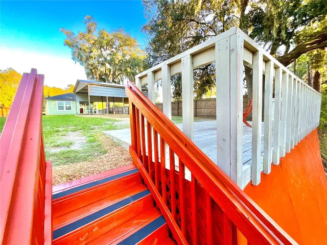 a view of a deck with a table and chairs next to a yard