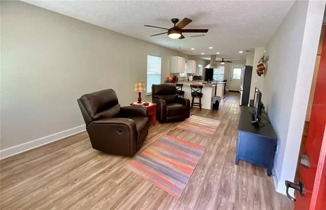 a living room with furniture and a wooden floor