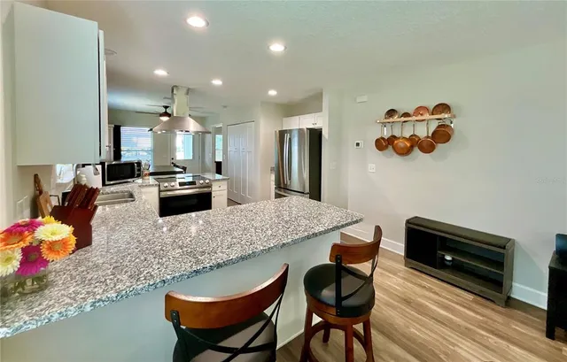 a kitchen with stainless steel appliances granite countertop a sink stove and refrigerator
