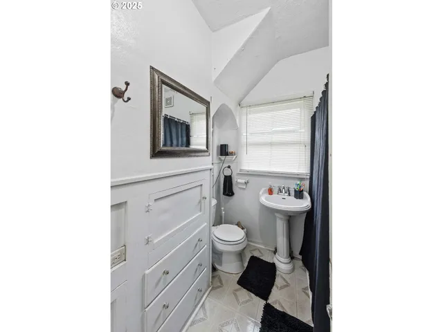 a bathroom with a toilet a sink and a mirror