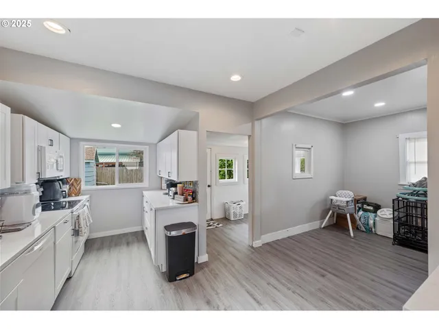 a kitchen with a table chairs refrigerator and cabinets