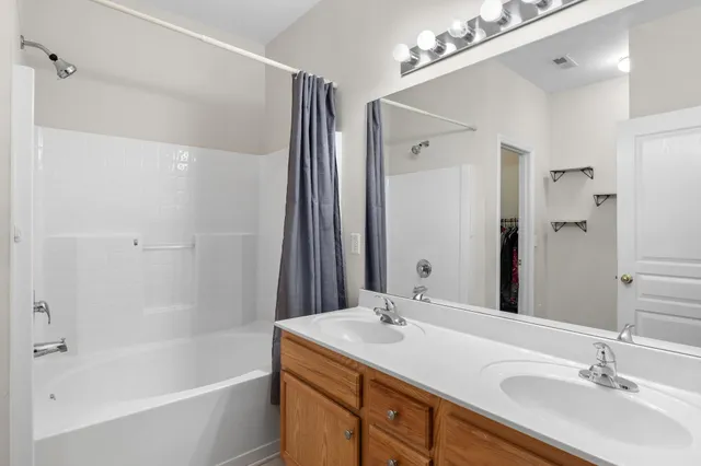 a bathroom with a tub double sink and mirror