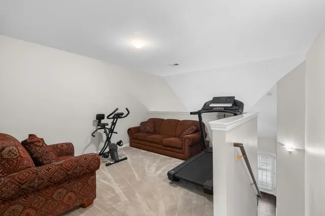 a living room with furniture and a gym machine