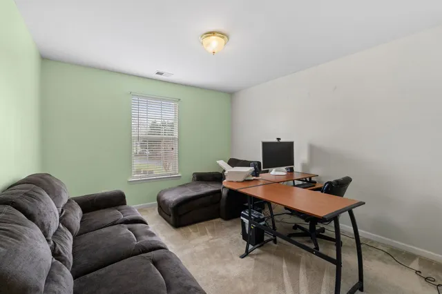 a livingroom with workspace and a couch