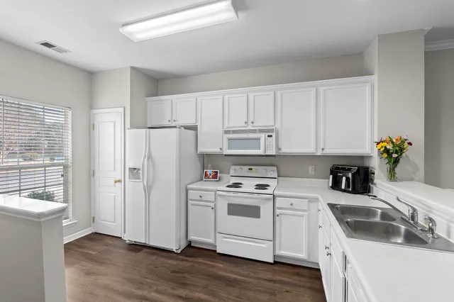 a kitchen with white cabinets and white appliances