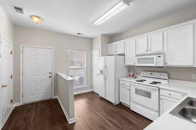 a kitchen with white cabinets and white appliances