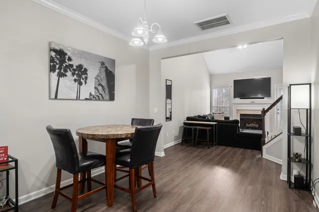 a view of a dining room with furniture a chandelier and wooden floor