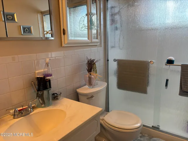 a bathroom with a sink a toilet and mirror