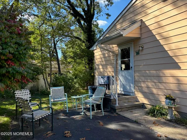 a view of backyard with outdoor seating and trees