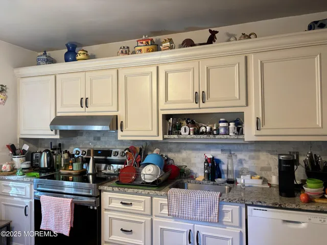 a kitchen with stainless steel appliances granite countertop a stove and cabinets