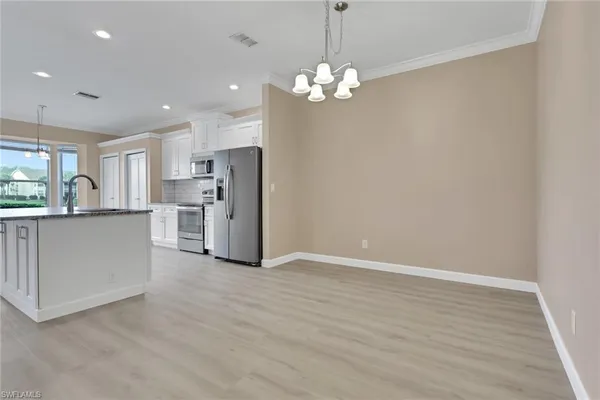 a view of a kitchen with refrigerator and a sink
