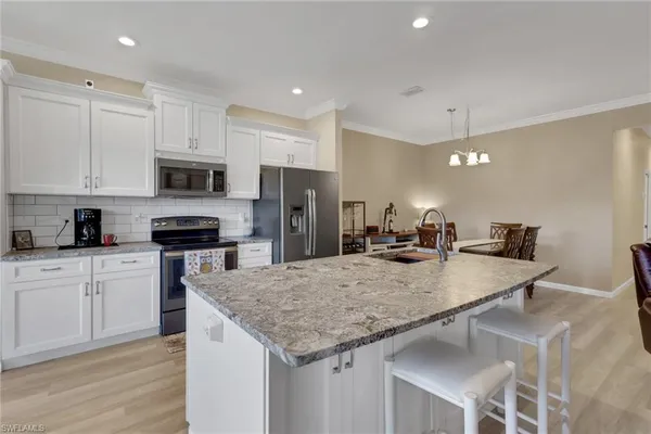 a kitchen with stainless steel appliances granite countertop a sink refrigerator and cabinets
