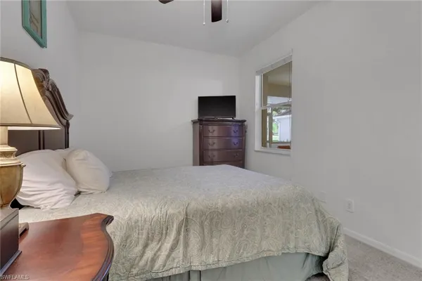 a bedroom with a bed and a flat tv screen on dresser