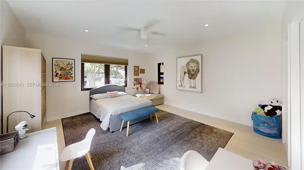 a large bedroom with a large bed and a flat tv screen