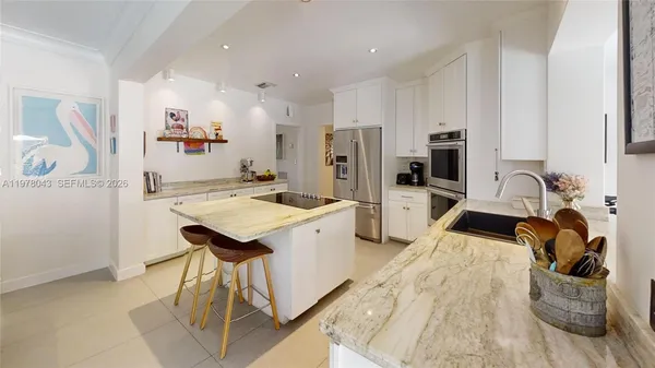 a kitchen with stainless steel appliances kitchen island granite countertop a refrigerator and a stove top oven