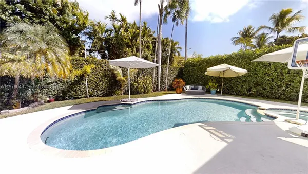 a view of a swimming pool with a table and chairs under an umbrella
