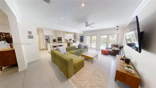 a living room with furniture wooden floor and a large window