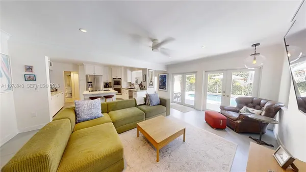 a living room with furniture kitchen view and a large window