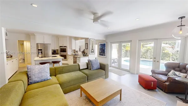 a living room with furniture flat screen tv and large window