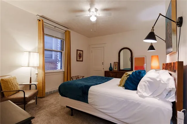 a bedroom with a bed mirror and window